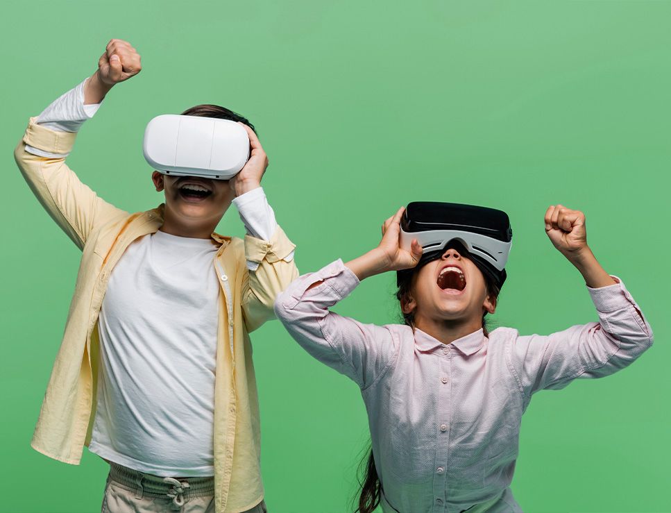 Two children cheering while wearing VR headsets