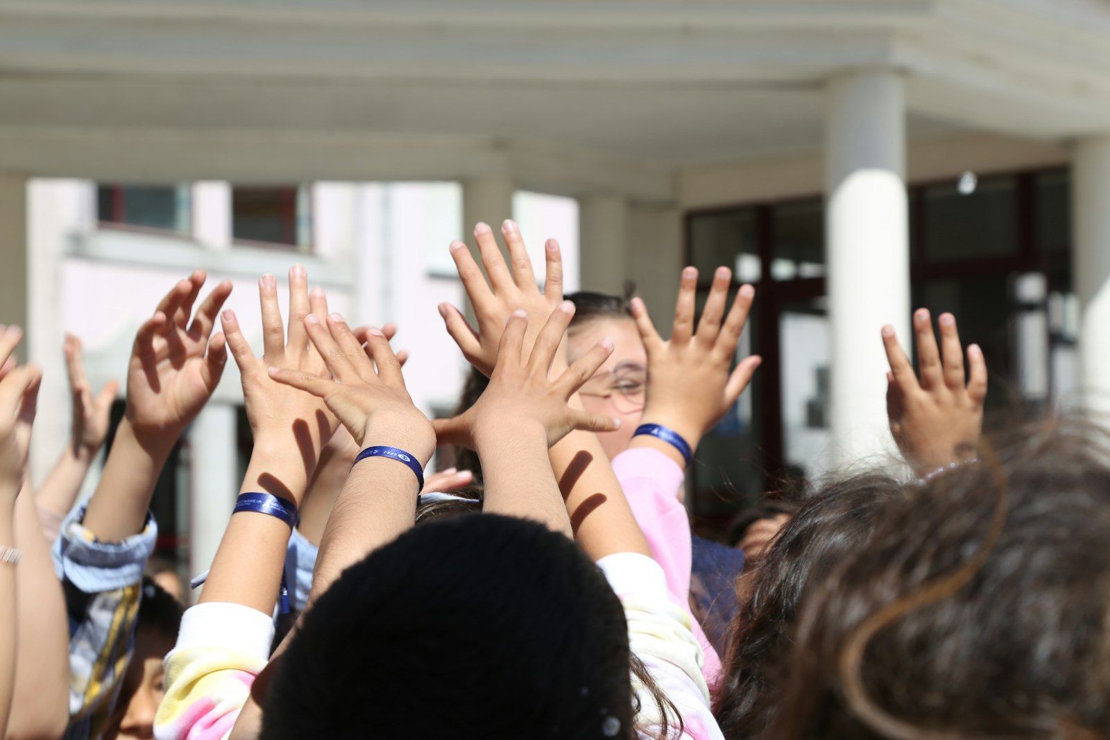 School children raising their hands excitedly